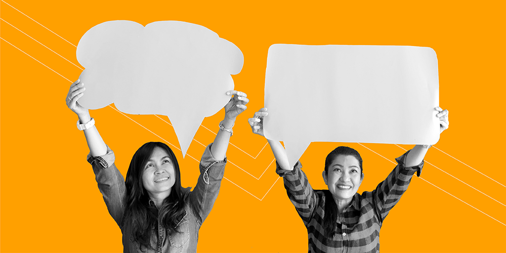 two women holding cutouts of thought bubbles