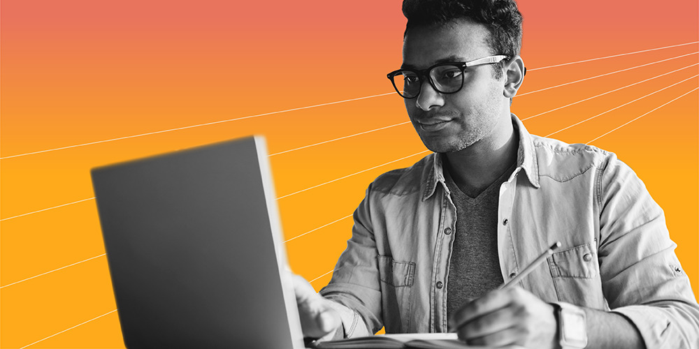 man with glasses reading the 2019 Financial Literacy Year in Review on his laptop