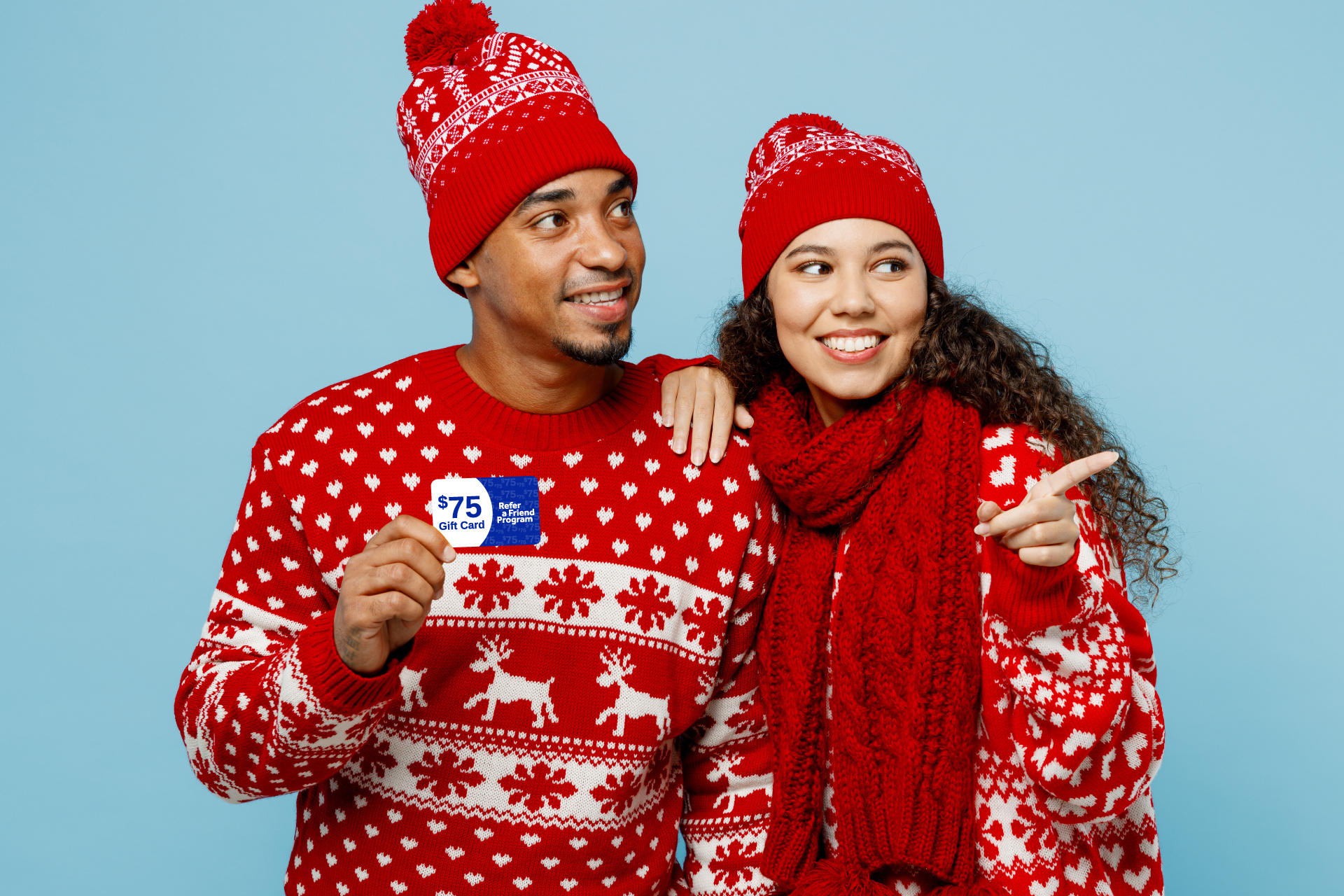 couple in winter attire holding a gift card